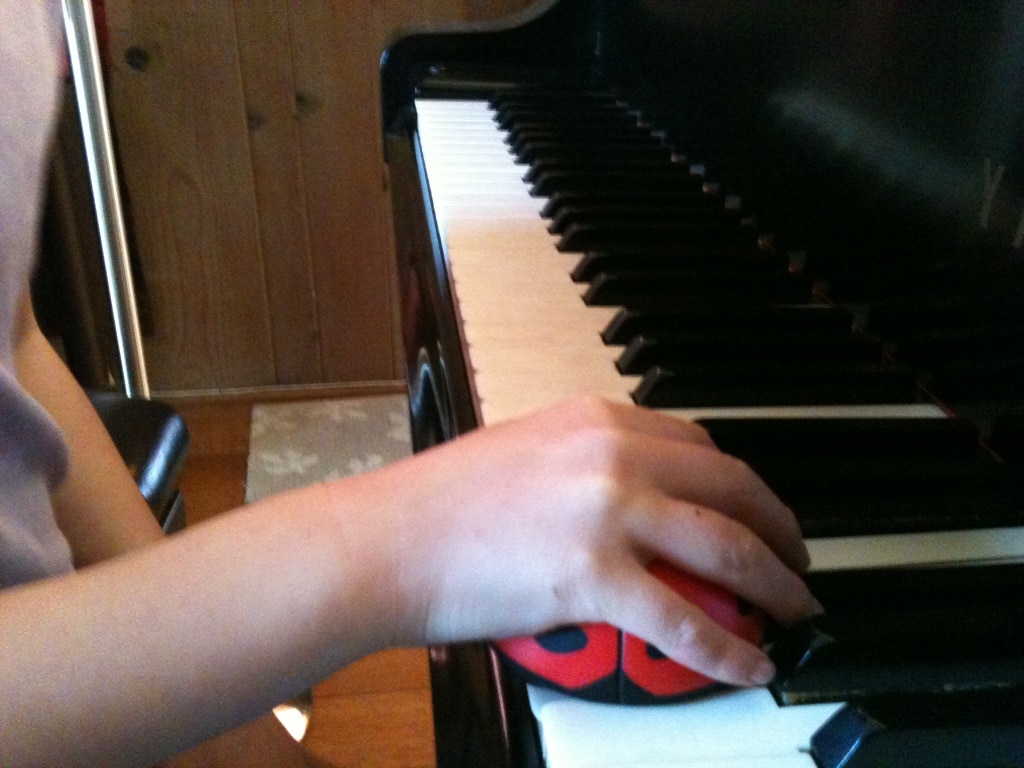 Piano student with ladybug to help hand position - Teaching Hand Position Online with Ladybugs and Giraffes