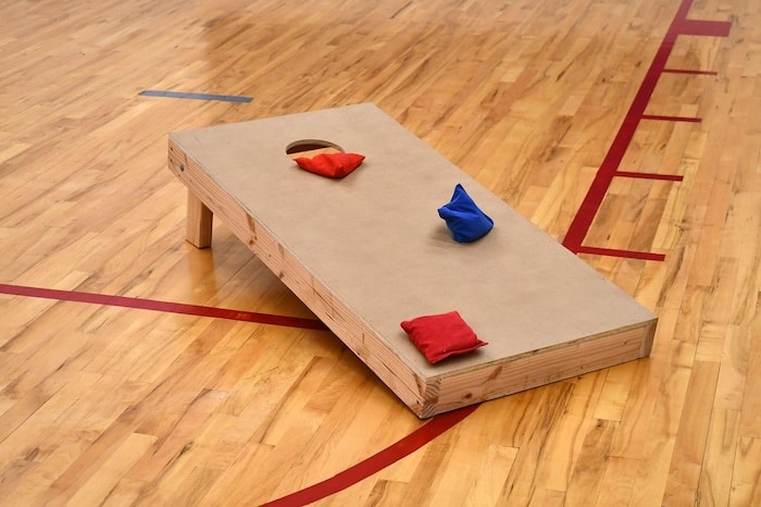 This image is of a cornhole game with 3 colorful beanbags resting on the game board. | 10 ways to use a beanbag for teaching piano | ComposeCreate.com